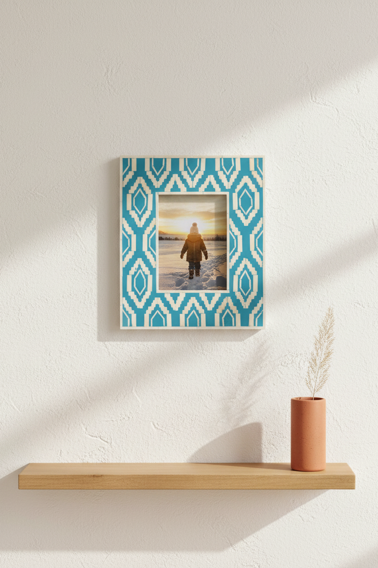 Framed artwork with geometric pattern on a wall above a wooden shelf.